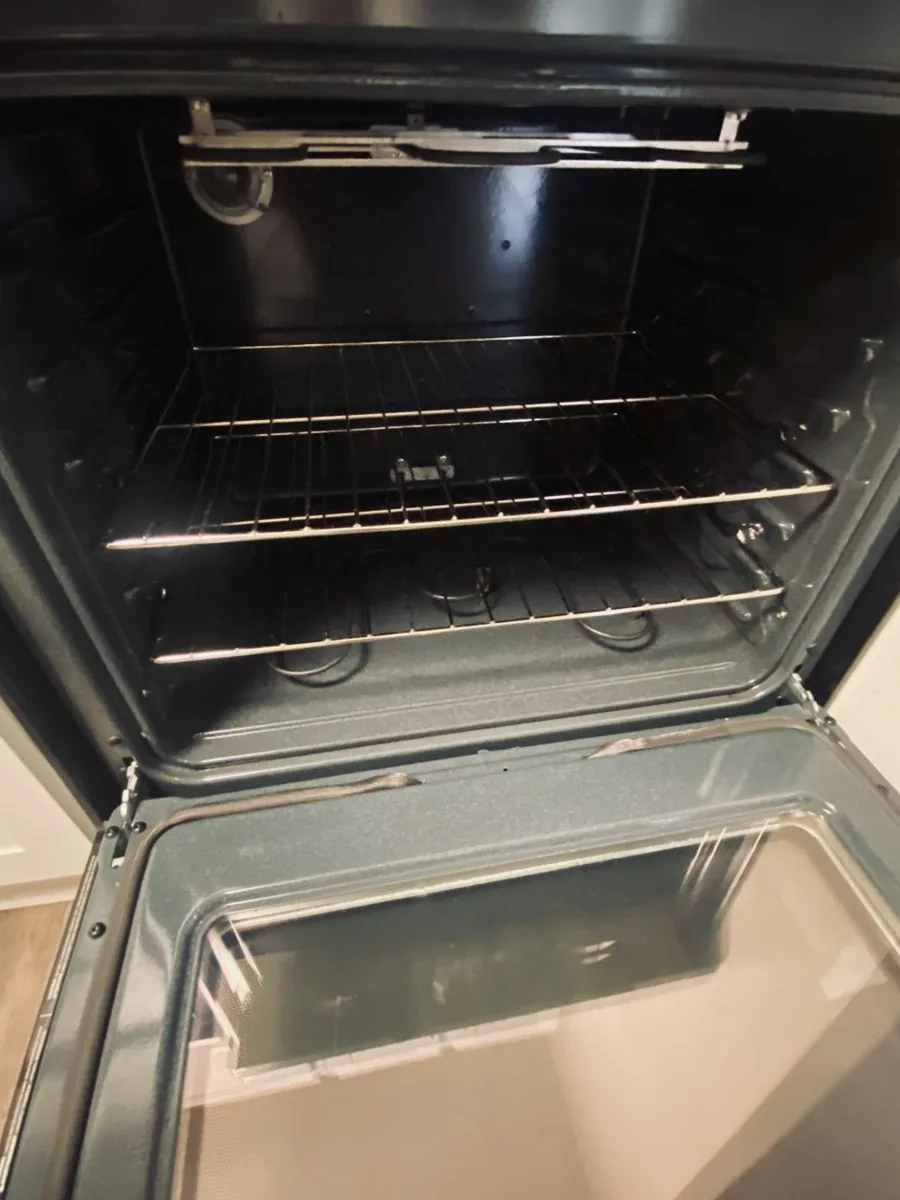 The sparkling clean interior of an oven with spotless racks after a deep cleaning